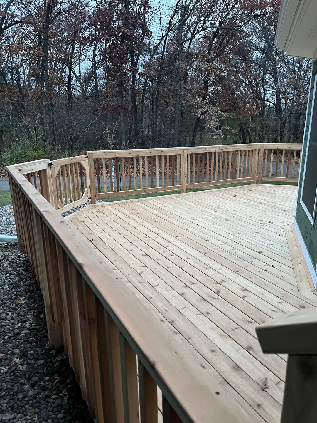 Newly built wooden deck surrounded by trees in a tranquil outdoor setting.