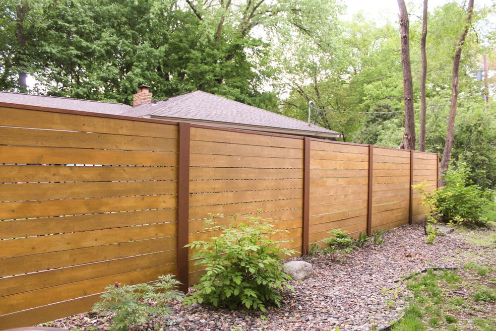 Wooden fence surrounding a backyard, offering privacy and natural landscaping.